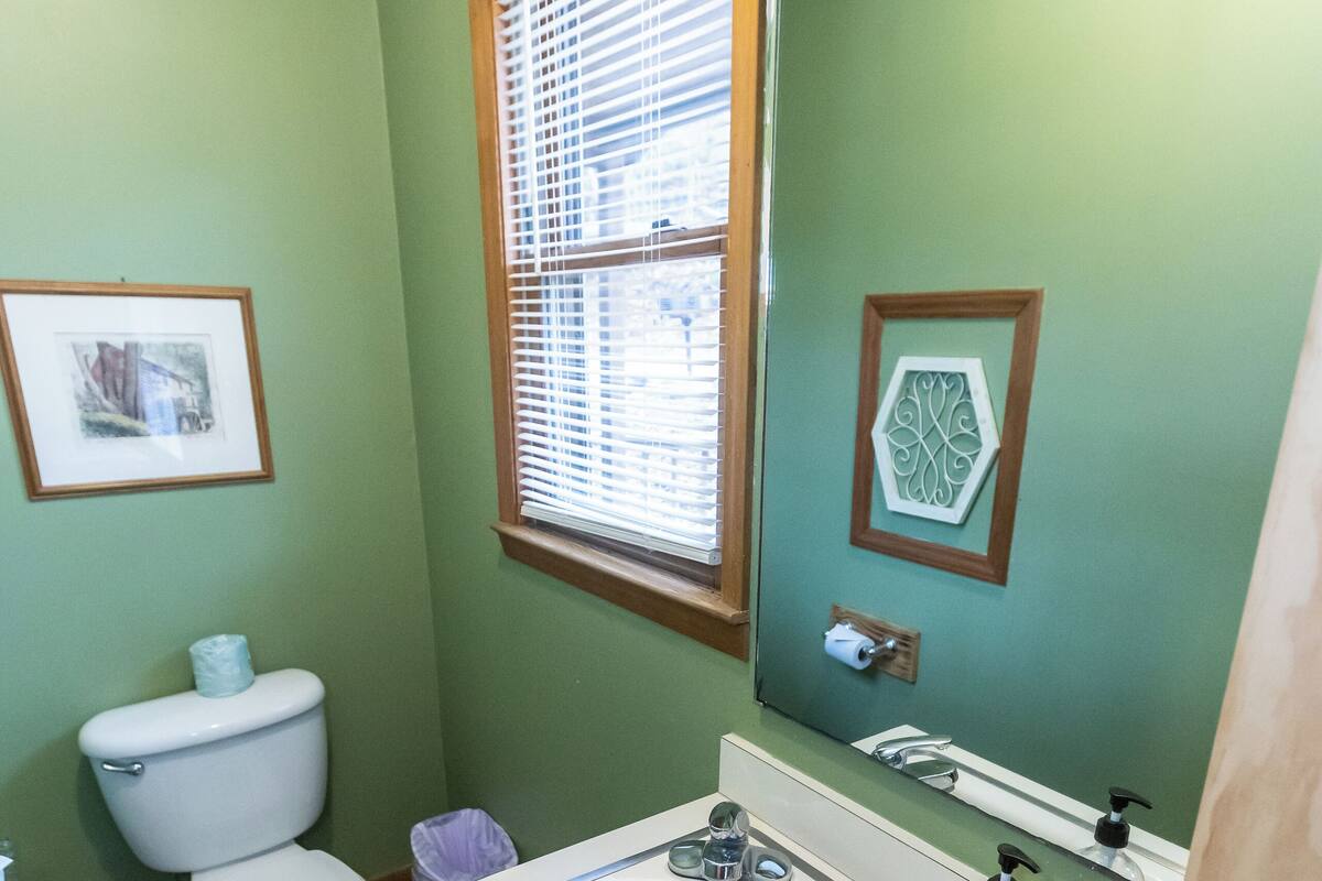 Une salle de bain avec des toilettes, un lavabo et un miroir.
