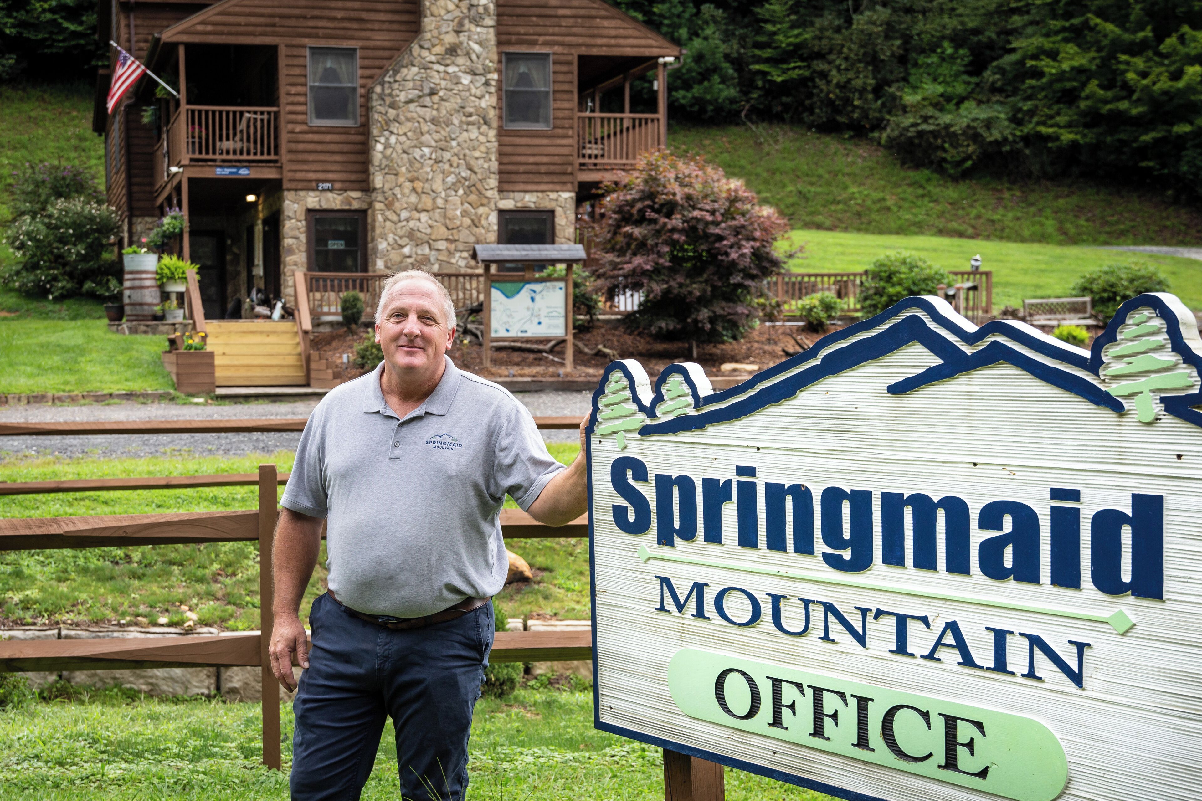 Een man staat voor een bord met de tekst 'Springmaid Mountain Office'.