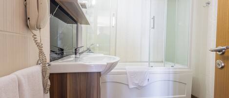 A bathroom with a sink, mirror, and telephone.