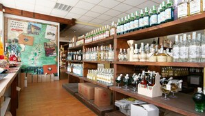A liquor store with shelves stocked with various bottles and boxes. - Motel Monterosa (Vogogna)