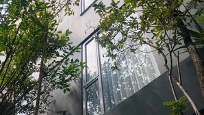 Un edificio moderno con ventanas amplias y árboles circundantes.