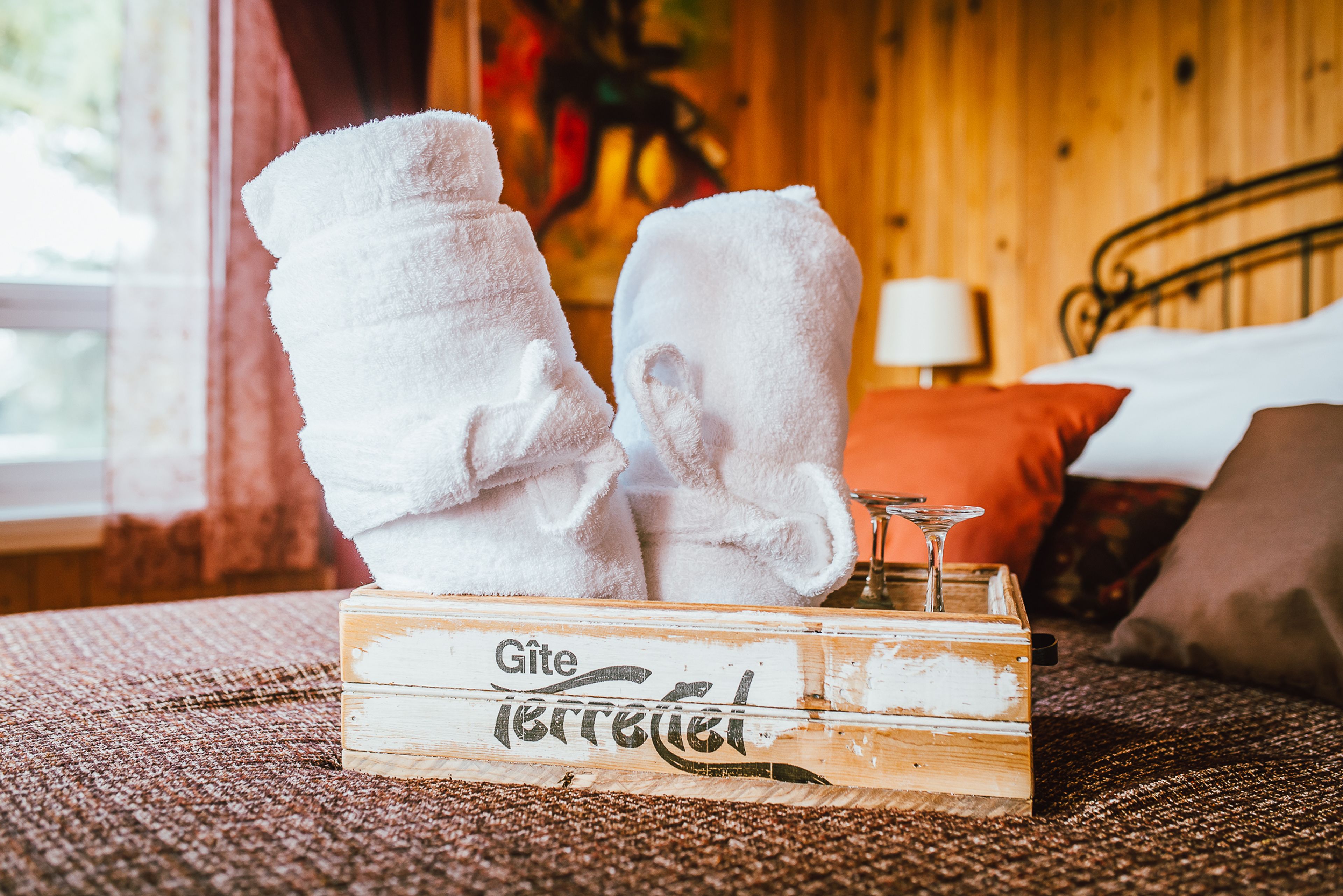 A wooden box labeled "Gite" with two white towels stacked on top.