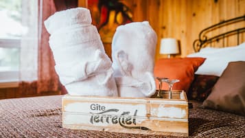 Una caja de madera con la etiqueta 'Gite' y dos toallas blancas apiladas encima.