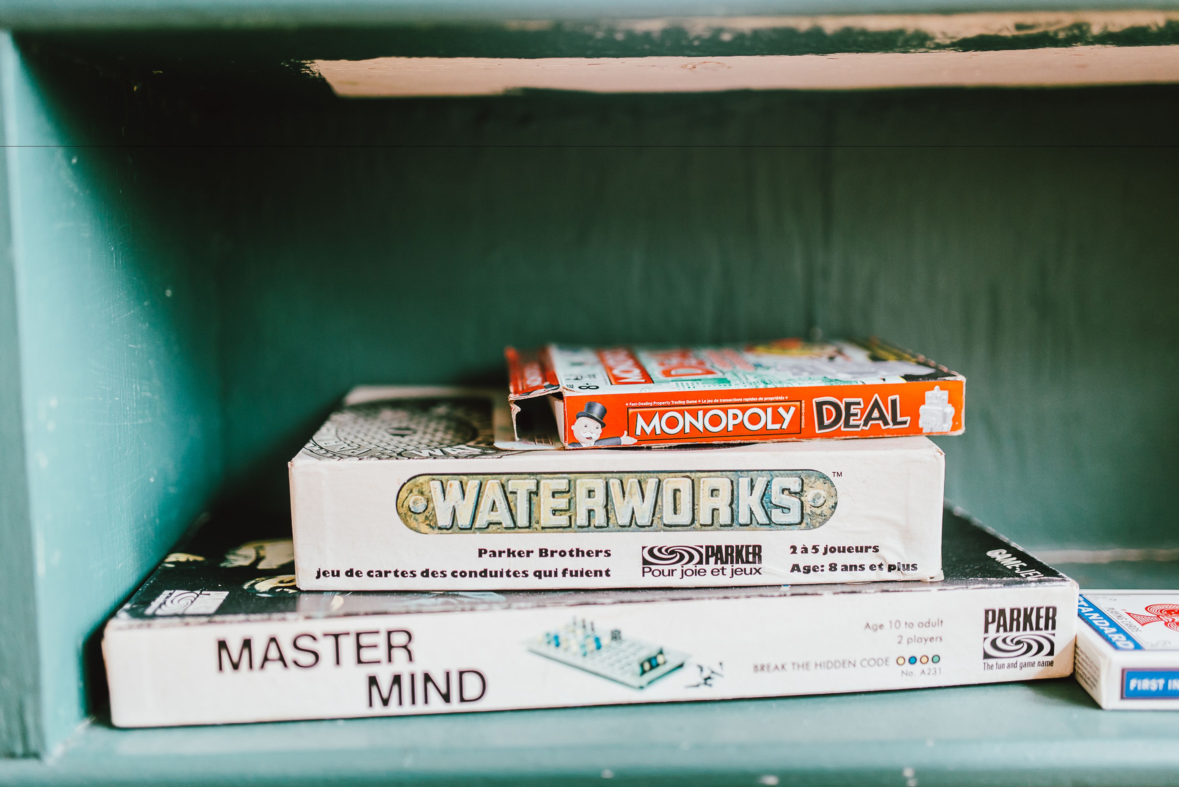 A stack of board games on a shelf.