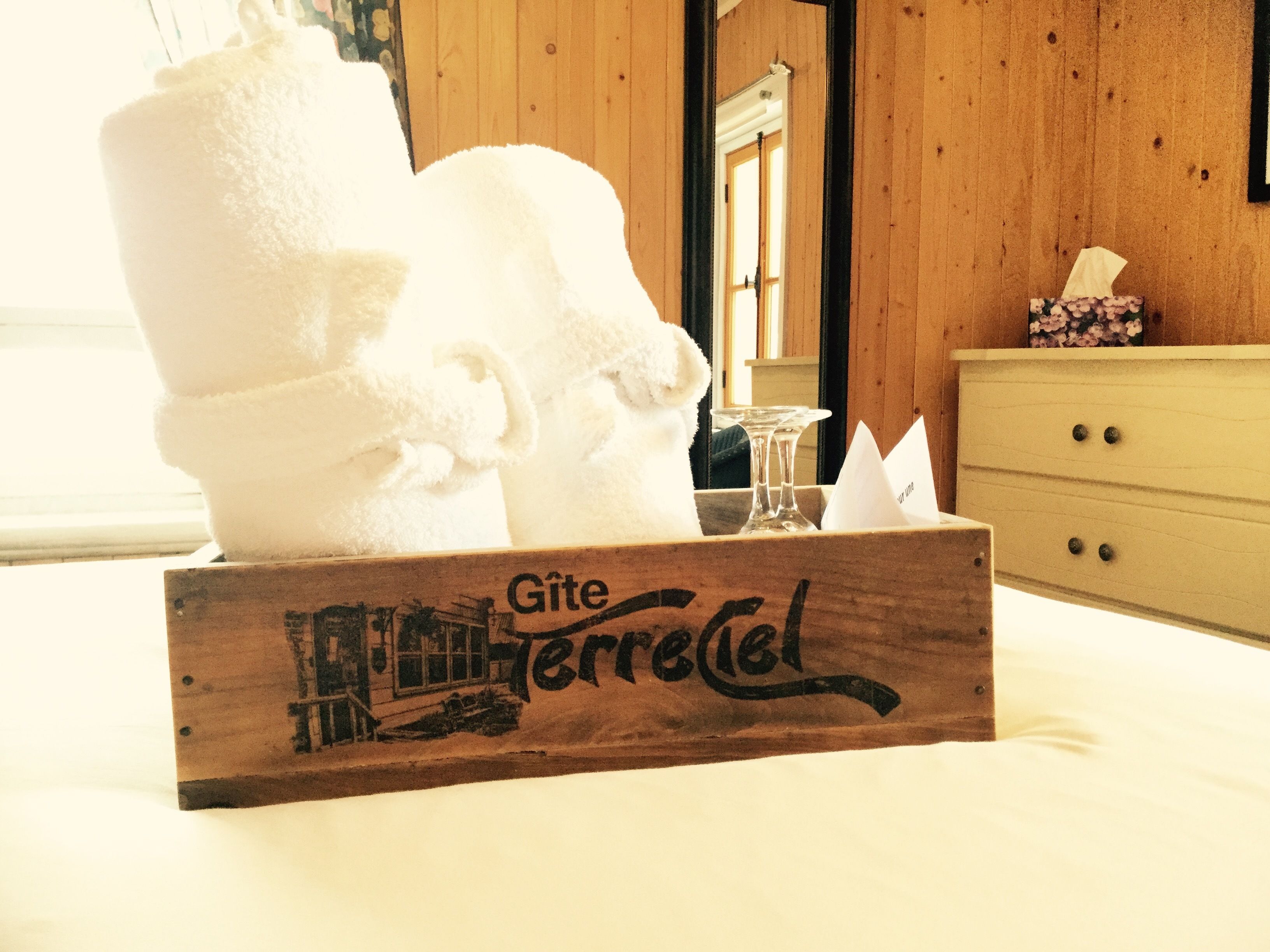 Een houten doos met een handdoek en een glas op een bed.
