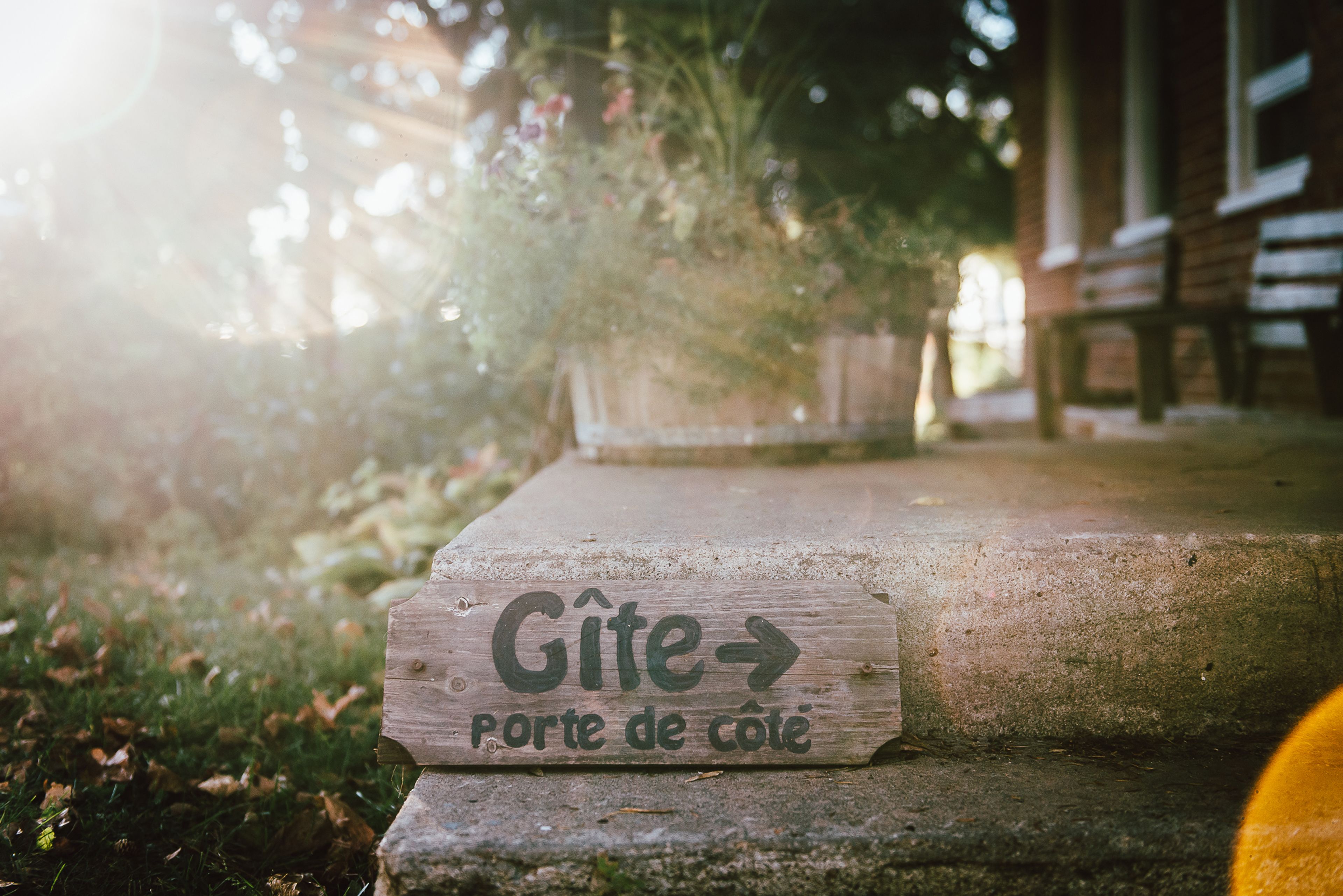 Una señal de madera con el texto 'Gîte porte de cote' que indica un alojamiento.