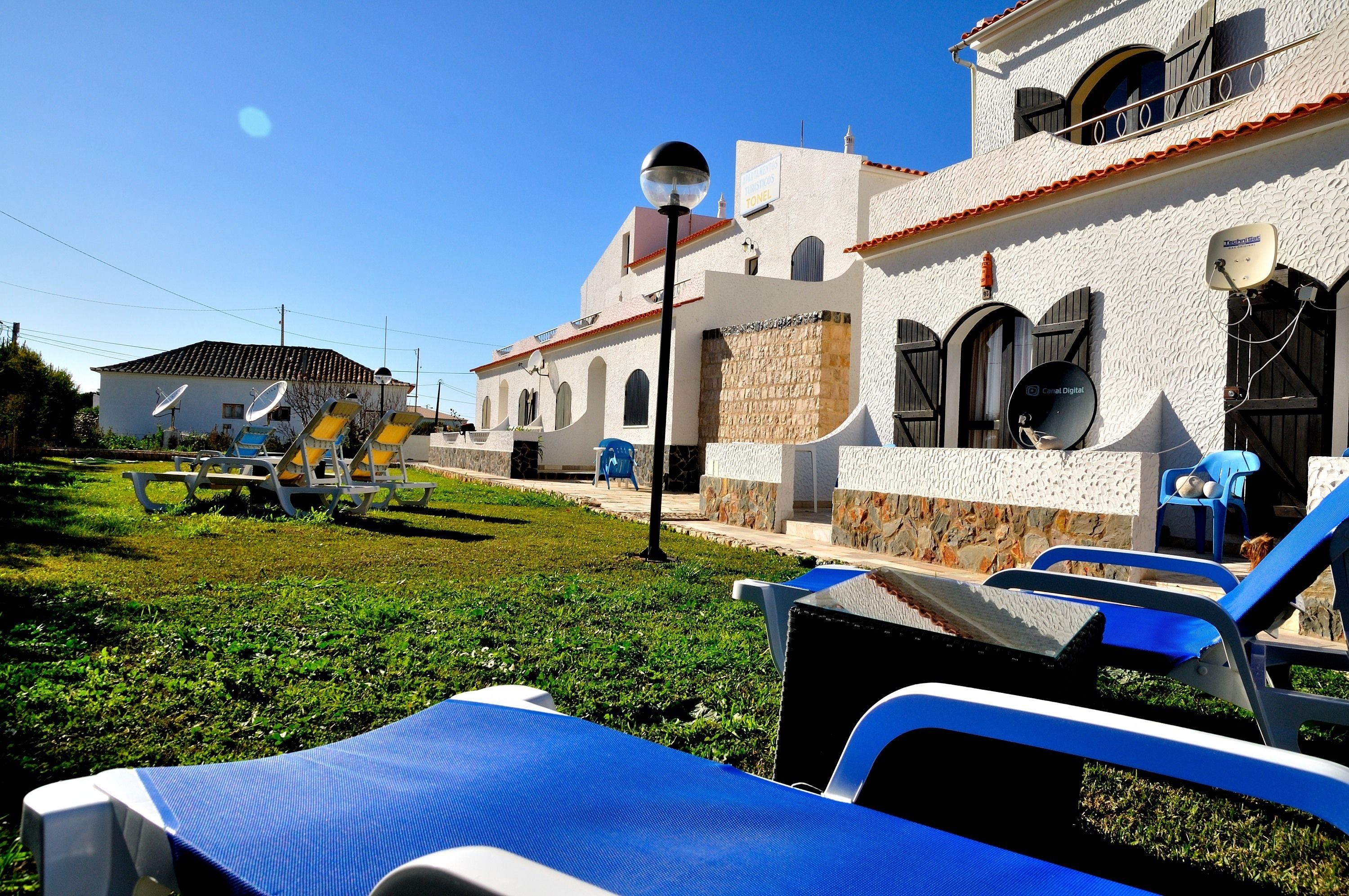 A building with a white exterior, stone accents, and multiple satellite dishes.