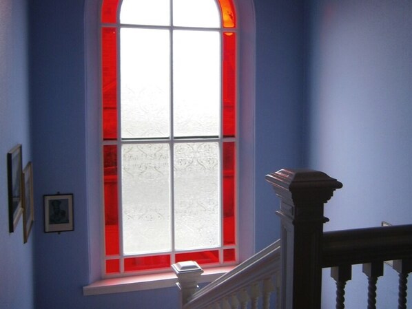 A room with a large window featuring a red frame and frosted glass. - Dorstan House (Edinburgh)