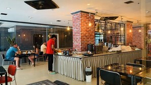 A modern cafe with a brick accent wall, a bar area, and seating for guests. - Patong Platinums (Patong)