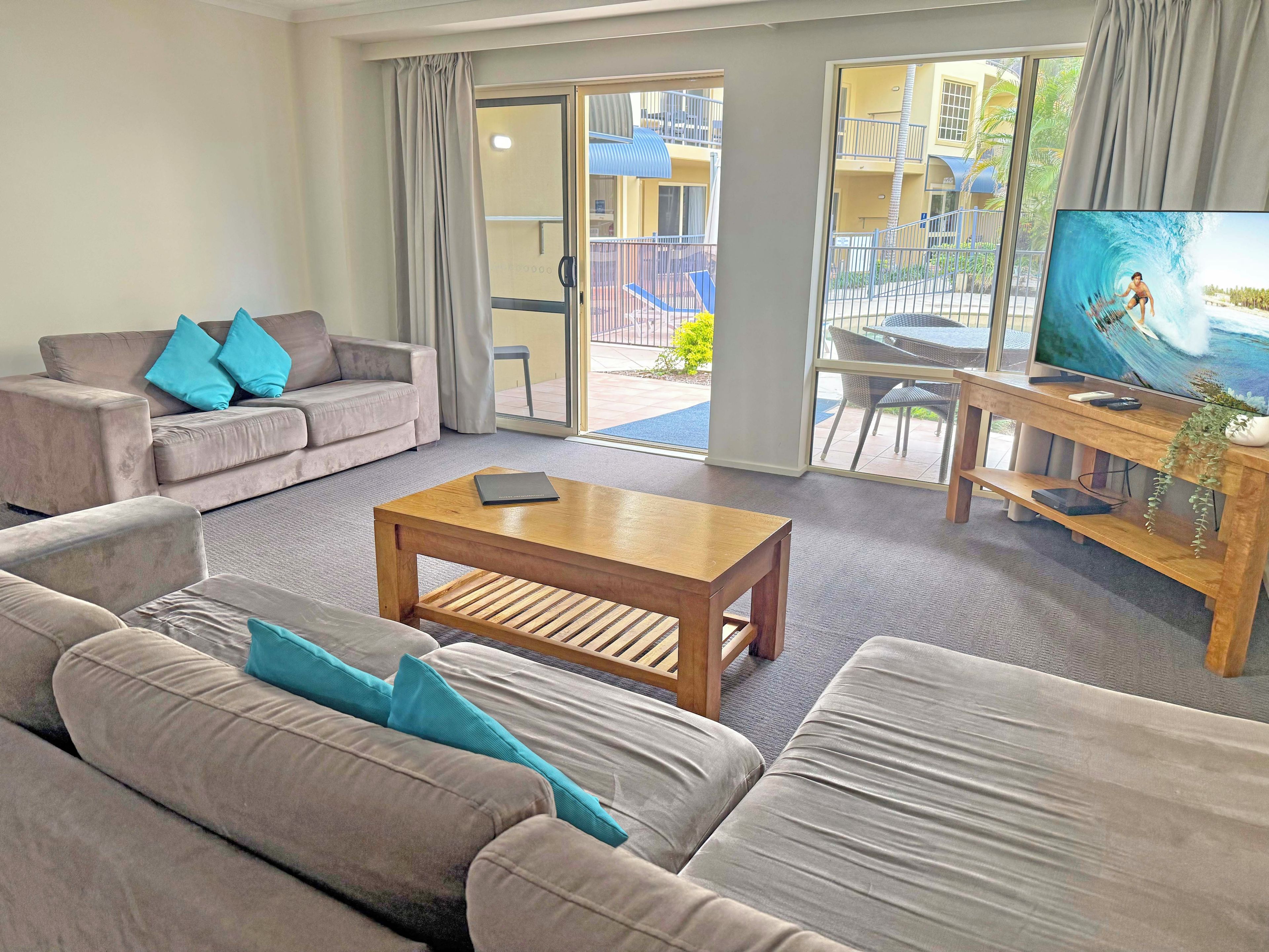 A modern living room with a sofa, a coffee table, and a television.