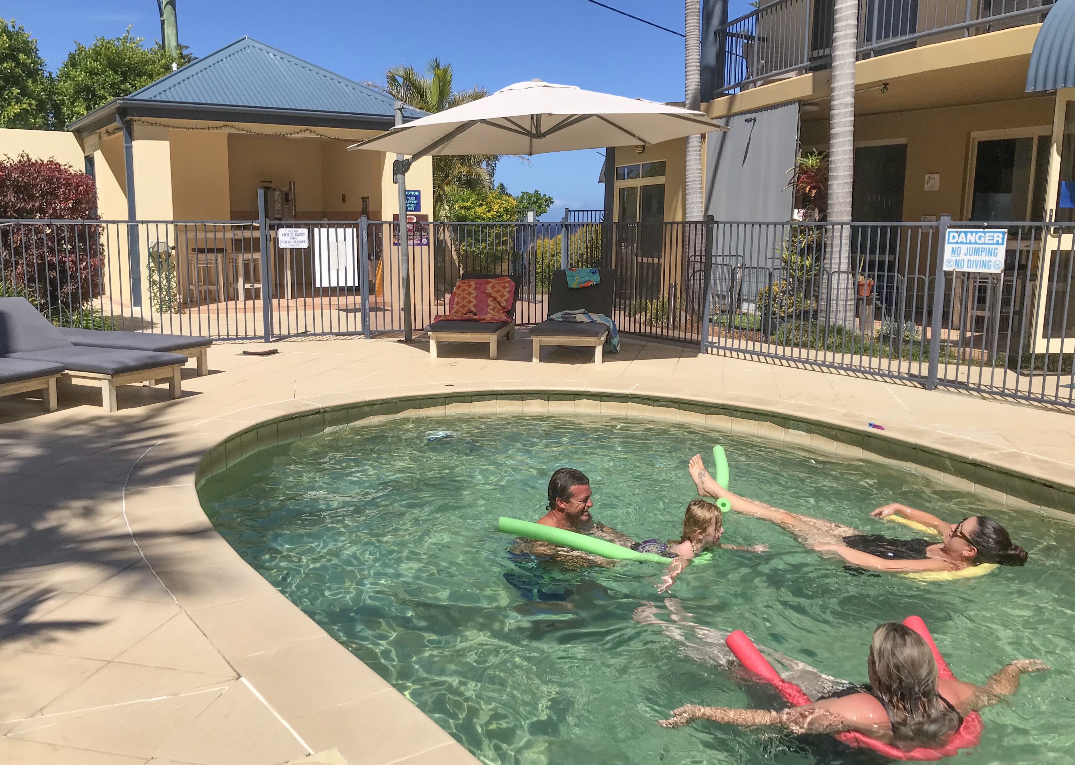 Utendørsbasseng,et oppvarmet basseng, bassengparasoller og solsenger