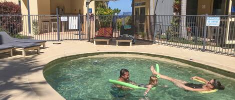 Utendørsbasseng,et oppvarmet basseng, bassengparasoller og solsenger