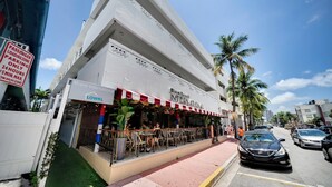 A restaurant with outdoor seating and a sign indicating a 15-minute parking limit. - Miami International by Lowkl (Miami Beach)