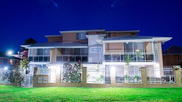 A two-story house with a sign reading "Coracagna Shares" on the front. - Copacabana Shores (Copacabana)