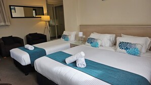 A hotel room with two beds, a sofa, a mirror, and a lamp. - Copacabana Shores (Copacabana)