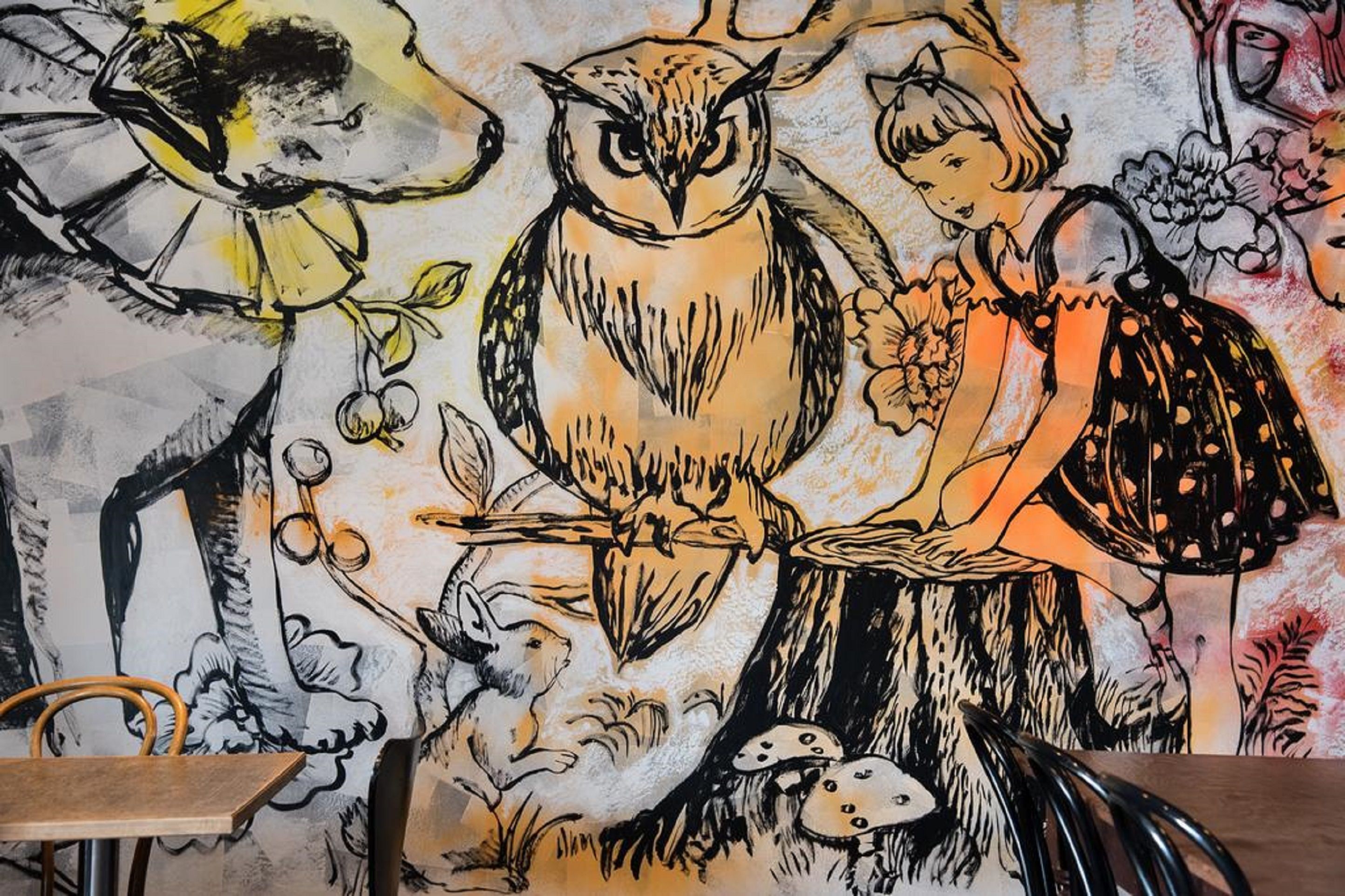 A mural with an owl, a girl, and flowers.