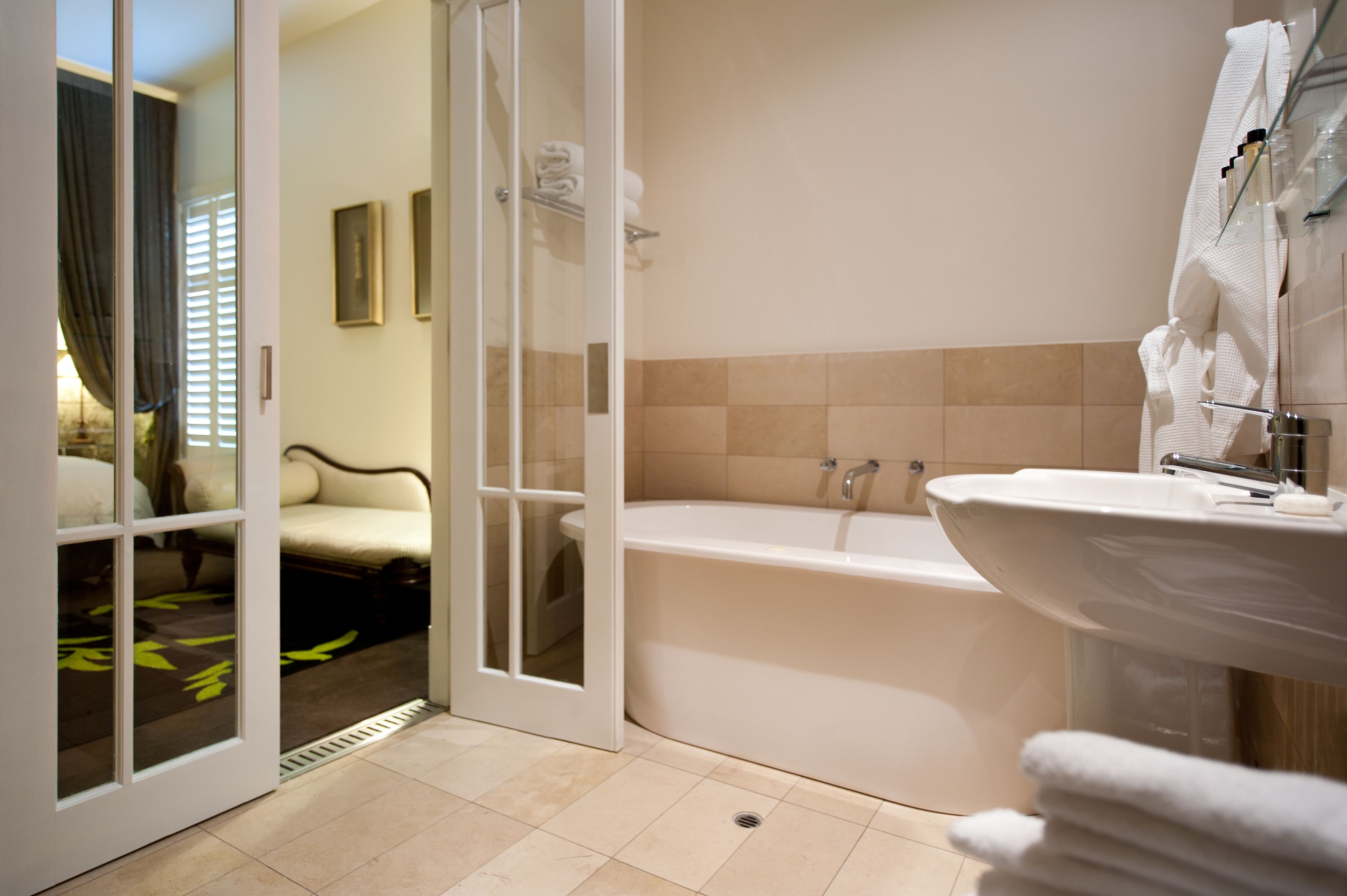 A modern bathroom with a bathtub, a sink, and a glass shower enclosure.