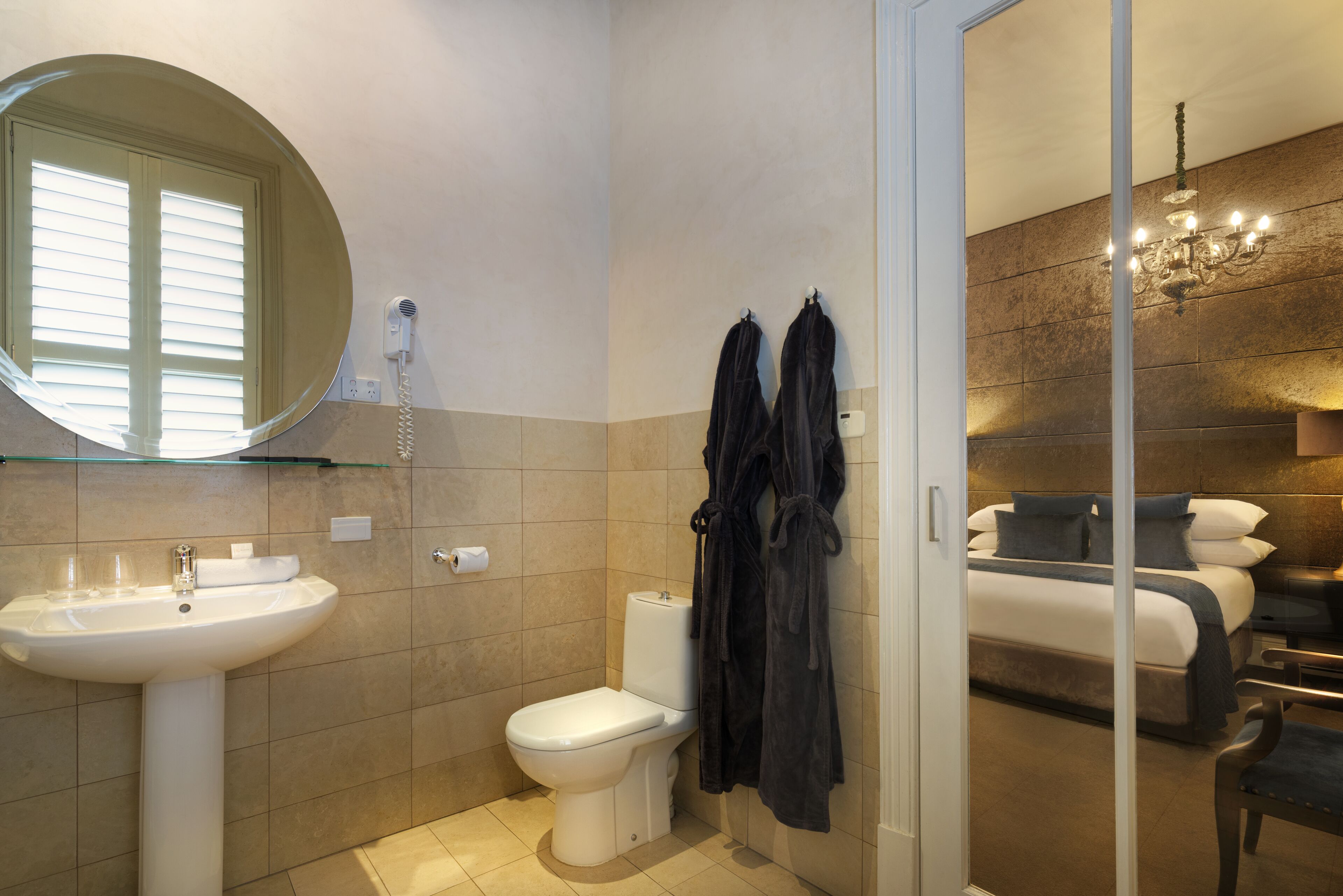 Een moderne badkamer met een wastafel, toilet en een douchecabine met glazen wanden.