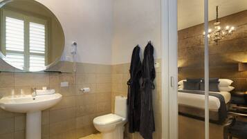 Een moderne badkamer met een wastafel, toilet en een douchecabine met glazen wanden.