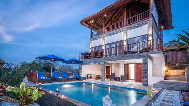 A two-story building with a swimming pool, outdoor seating, and a thatched-roof structure. - Villa Keluarga (Lembongan Island)