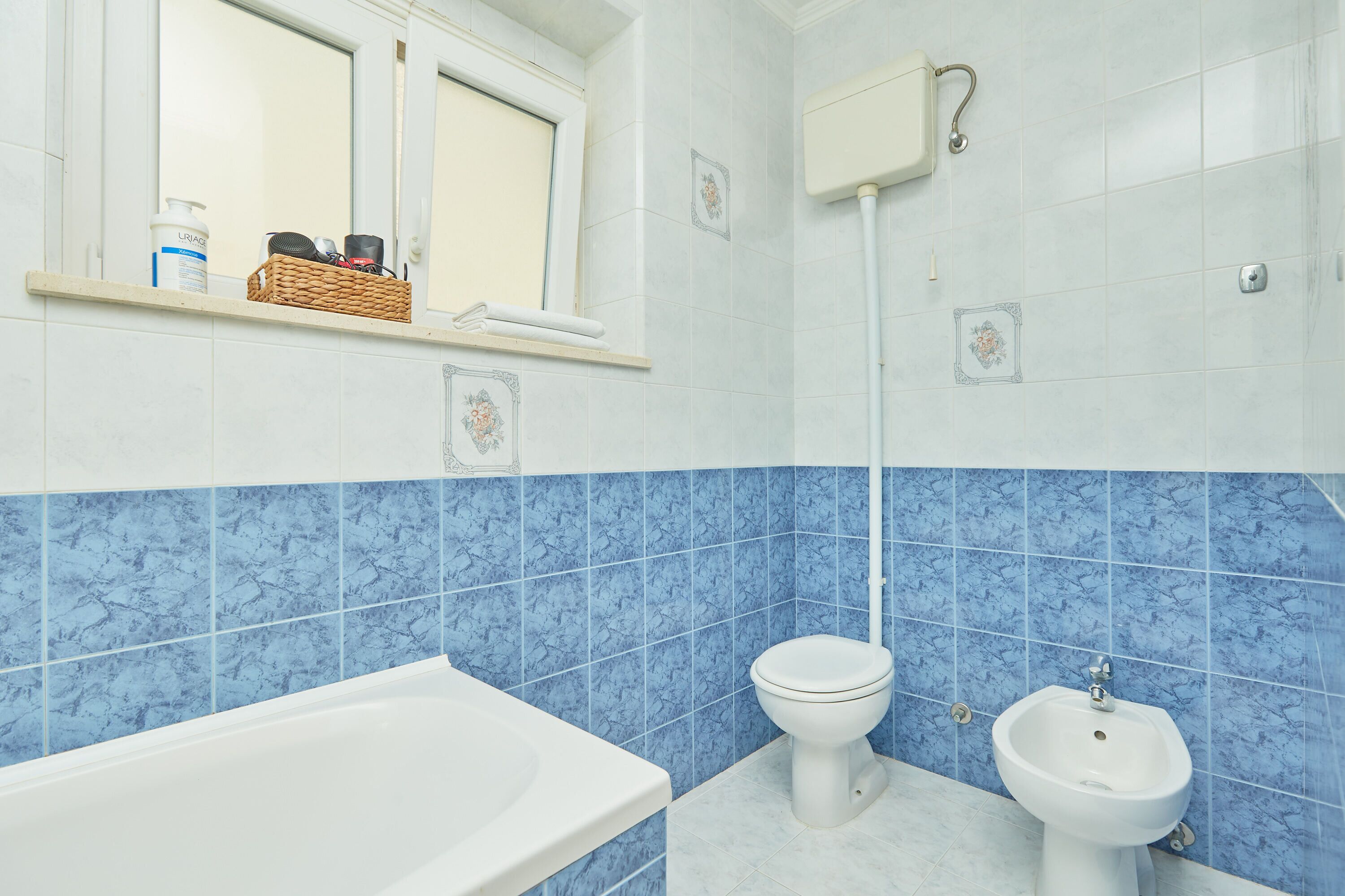 A bathroom with a bathtub, toilet, and bidet.