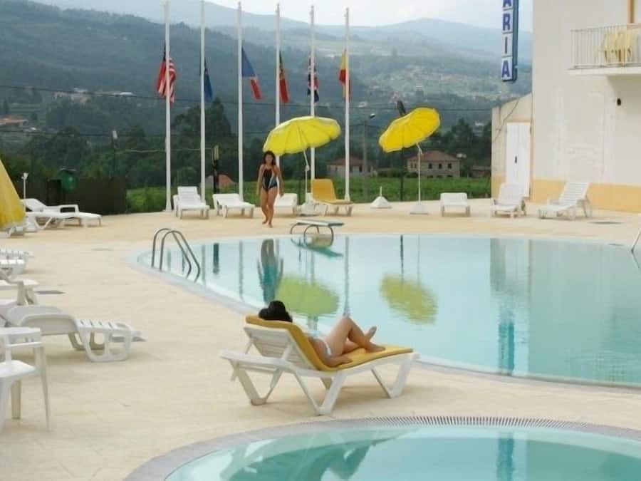Una piscina al aire libre de temporada, sombrillas