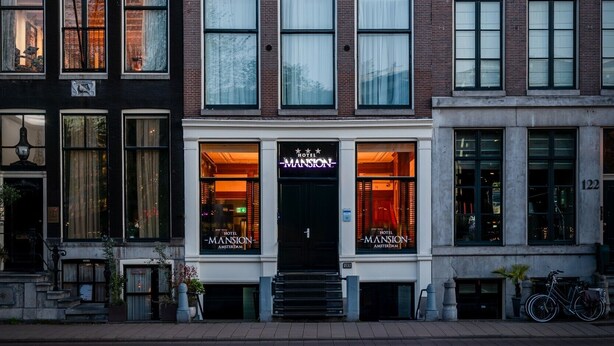 A row of historic buildings with a hotel named 'Mansion' on the ground floor. - Hotel Mansion (Amsterdam)