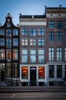 Une rangée de bâtiments historiques, dont l’un, situé au rez-de-chaussée, abrite un hôtel appelé « Mansion ».