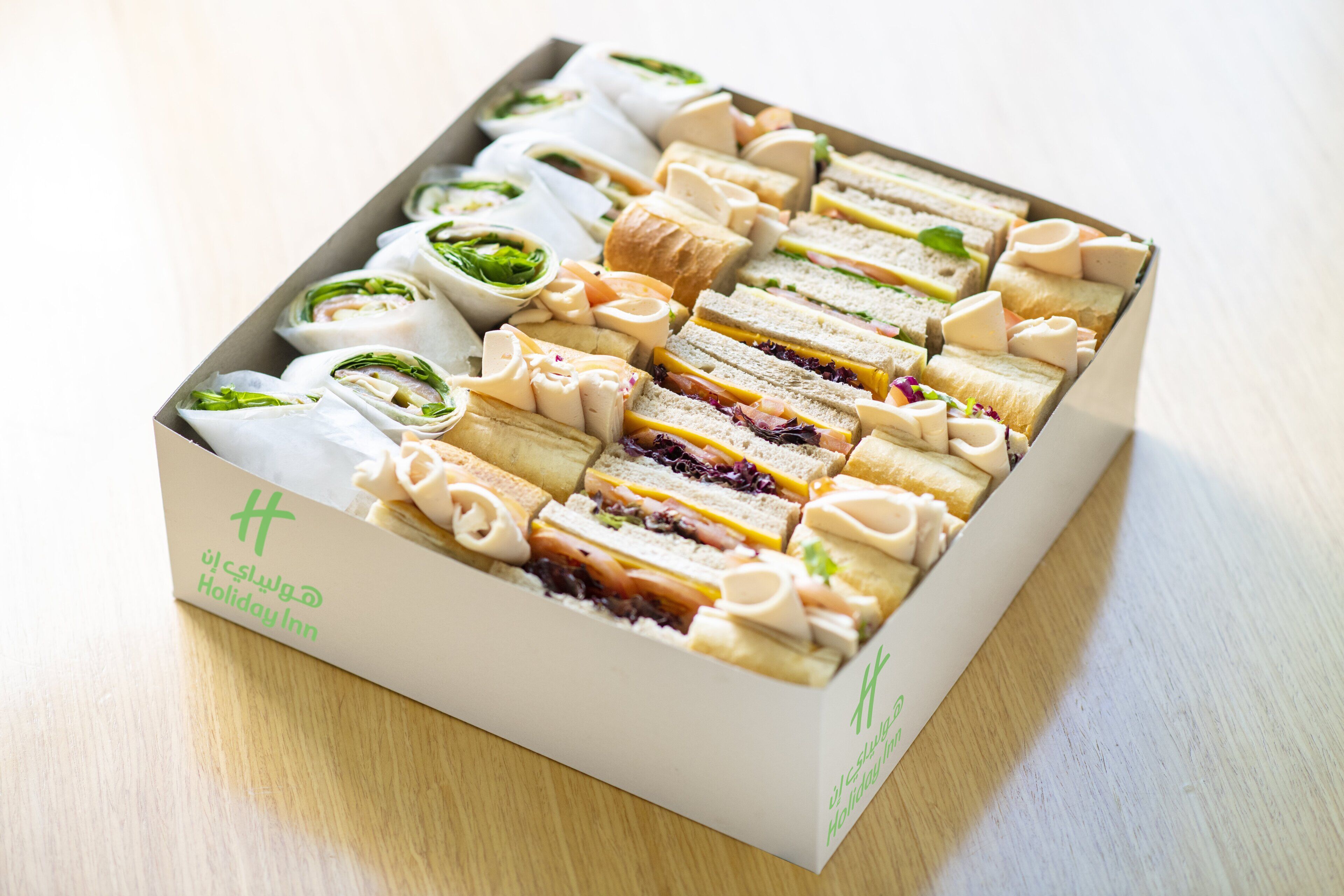 Uma caixa com sanduíches e pães variados, identificada como "Holiday Inn".
