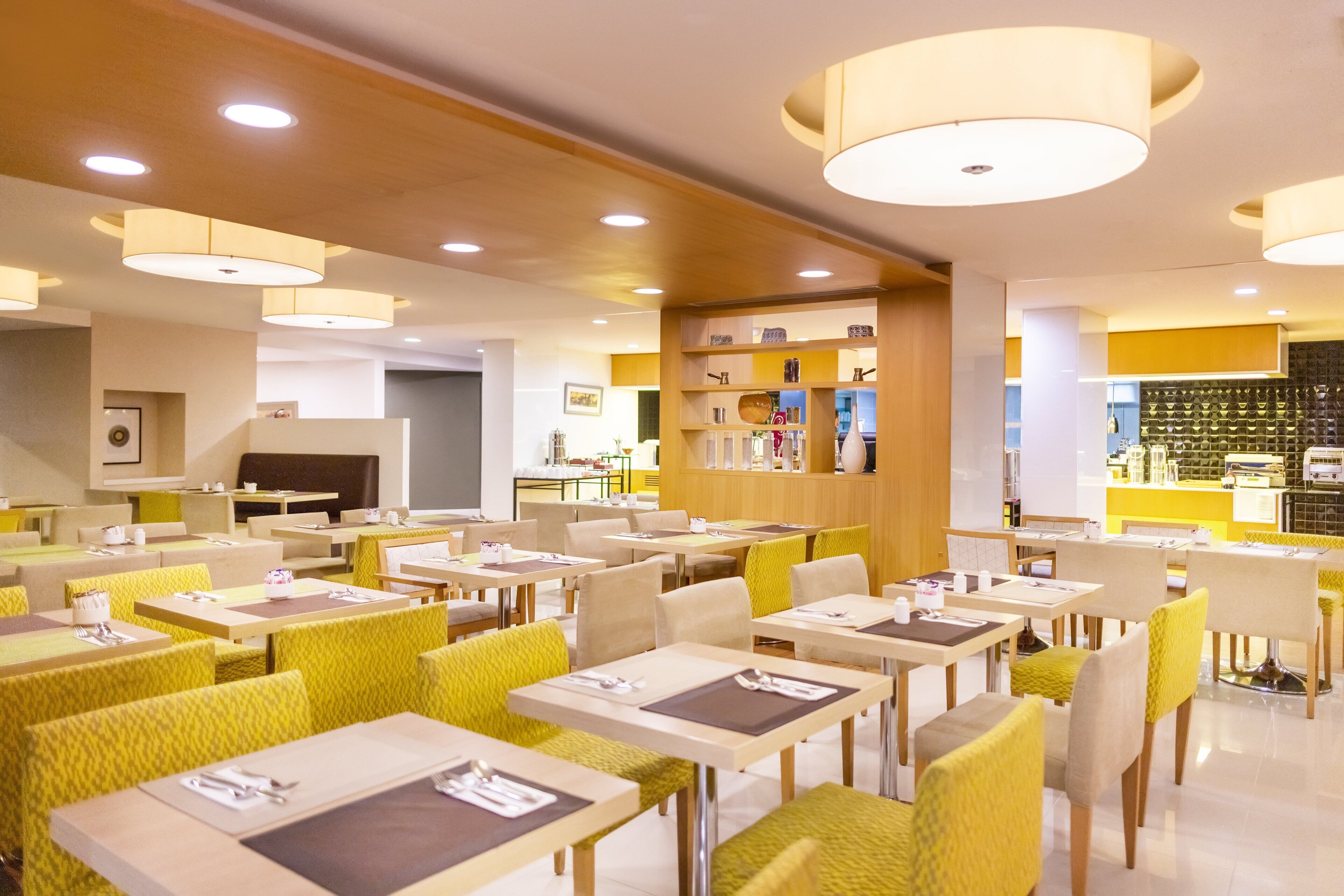 A modern restaurant with multiple dining tables and chairs, featuring a clean and organized layout.