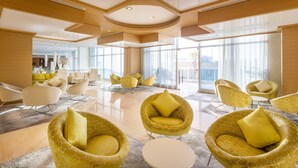 A spacious lobby with modern furniture, large windows, and a clean, polished floor.