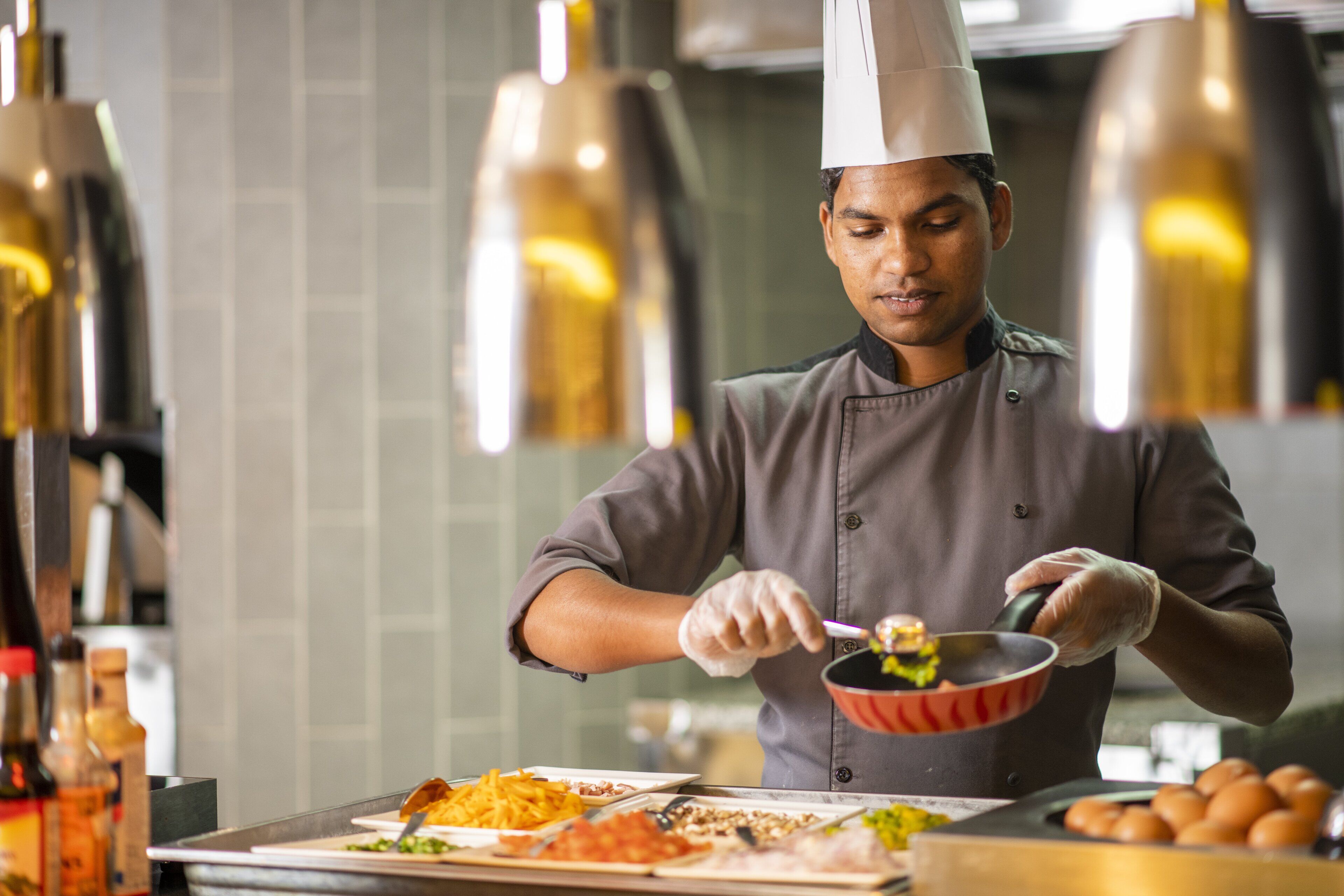 A chef in a professional kitchen preparing food.