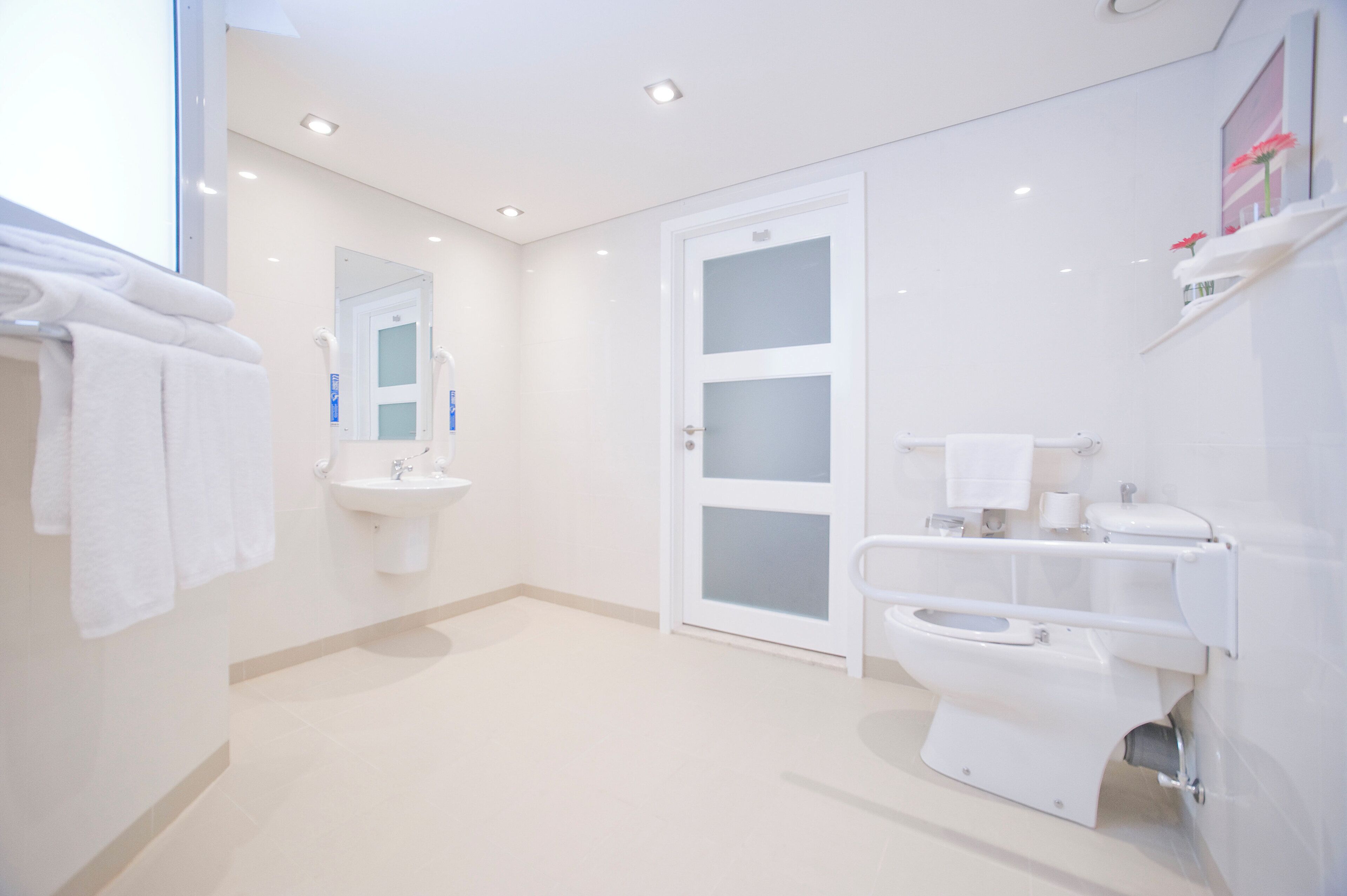 A modern bathroom with a toilet, sink, and mirror.