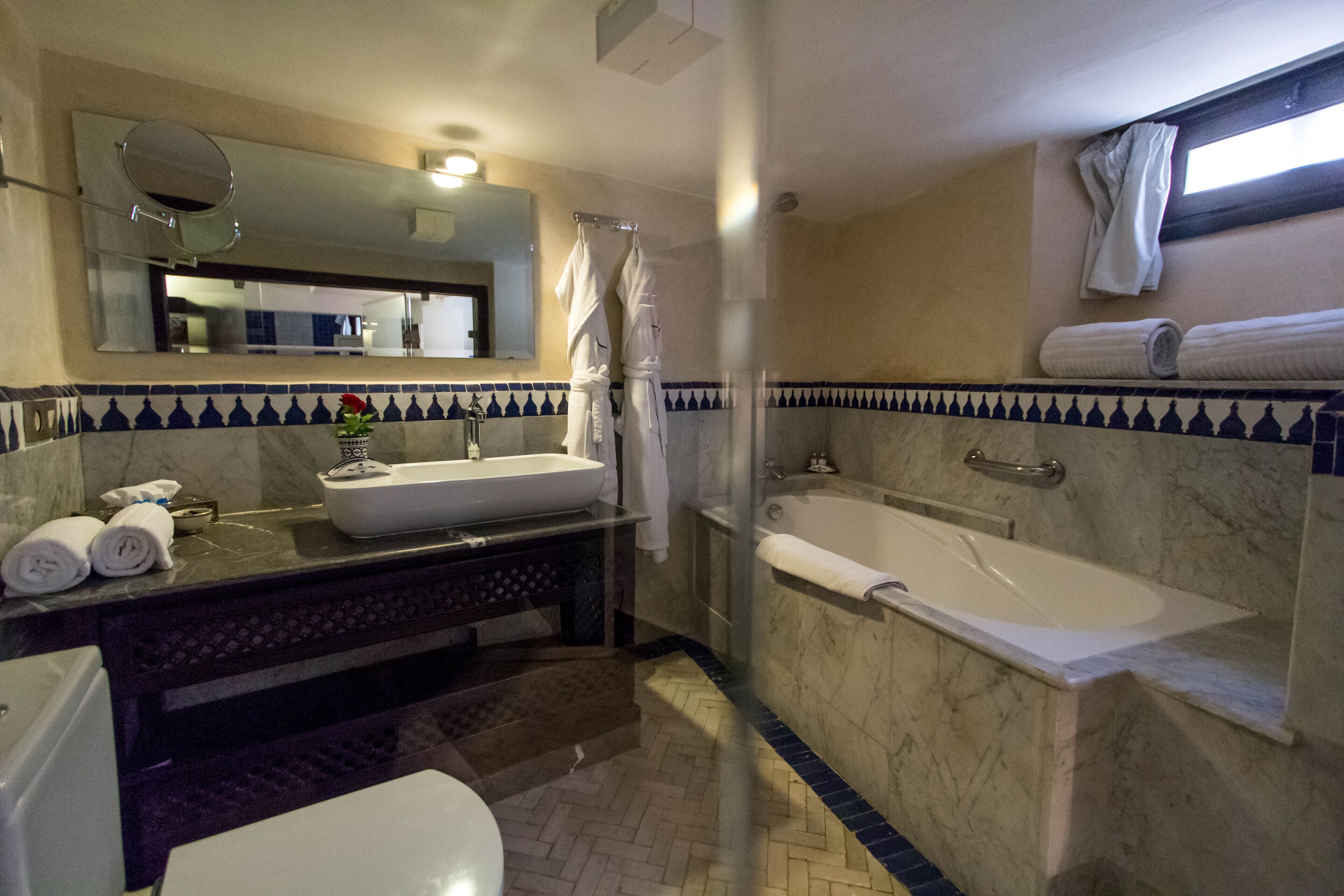 Une salle de bain équipée d’un lavabo, d’un miroir, d’une baignoire et d’un espace douche.