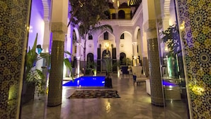 A luxurious indoor courtyard with a pool, ornate columns, and a central fountain. - Riad Braya  (Fès)