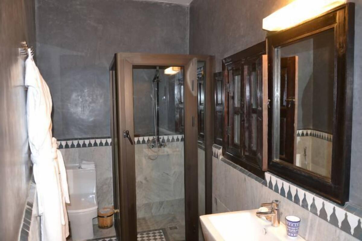 A bathroom with a shower, a toilet, a sink, and a mirror.