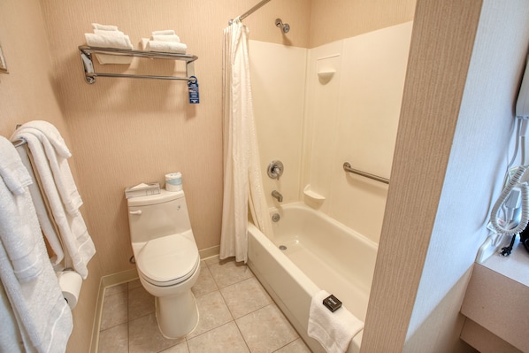 A bathroom with a toilet, a bathtub, and a shower curtain.