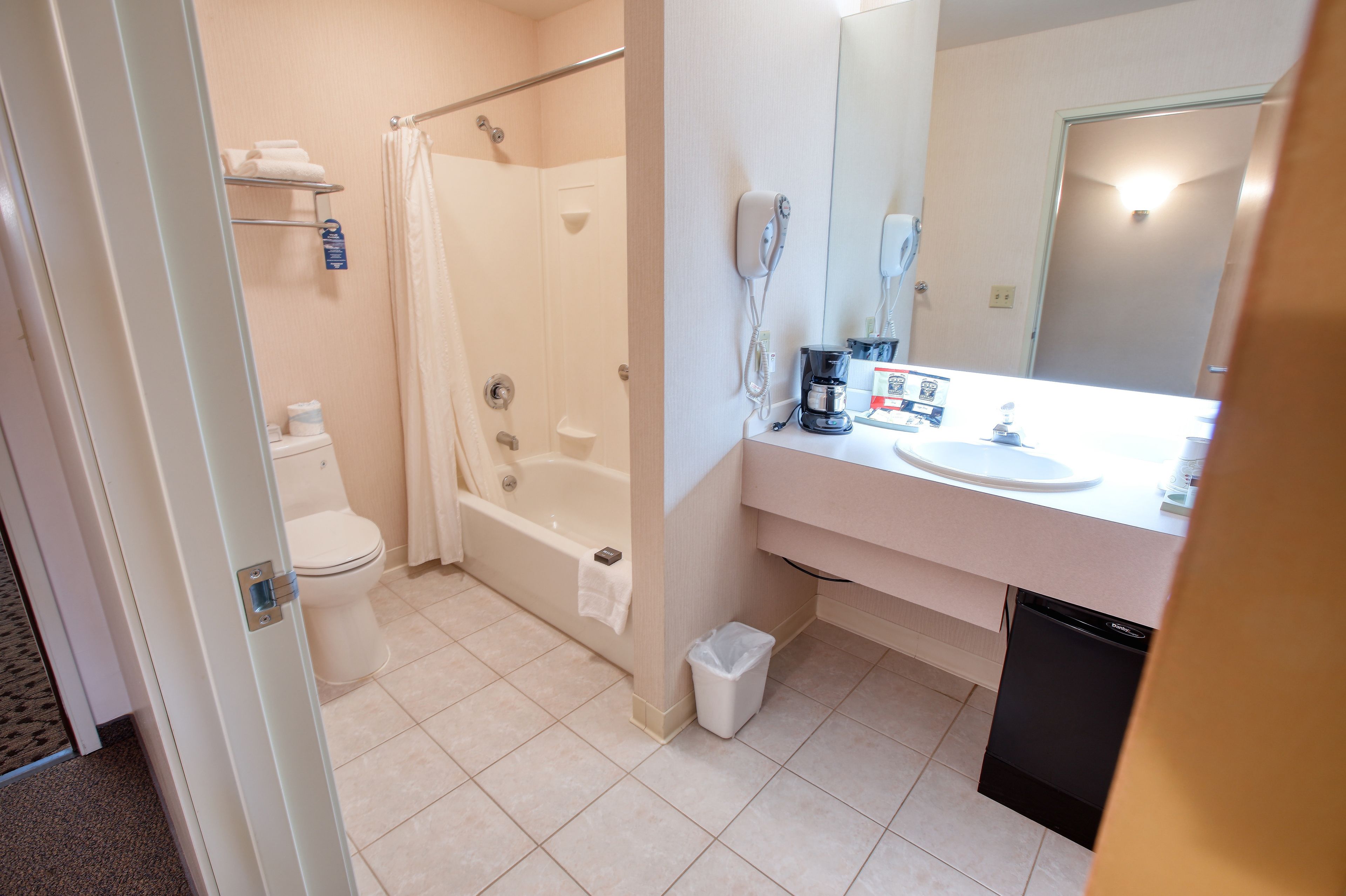 Un baño con inodoro, bañera, ducha, lavabo y cafetera.