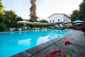 Una piscina al aire libre de temporada, sillones reclinables de piscina
