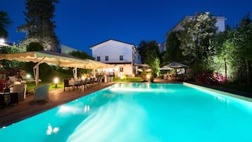 Una piscina al aire libre de temporada, sillones reclinables de piscina