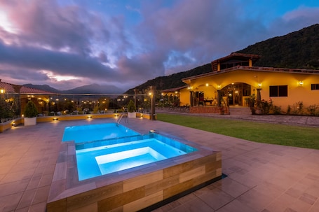 A pool area with a house in the background.