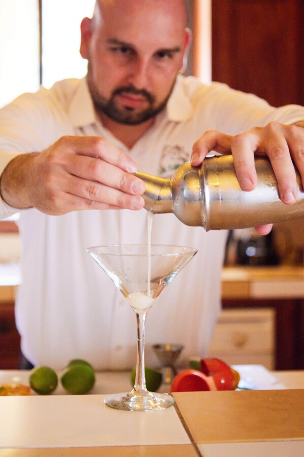 A person pouring a clear liquid into a martini glass. - Los Establos Boutique Resort- All Inclusive- Tours Included (Jaramillo)