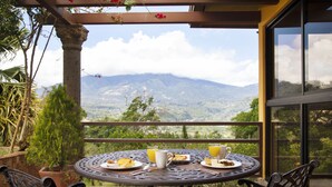 A round table with breakfast items and a mountain view. - Los Establos Boutique Resort- All Inclusive (Jaramillo)