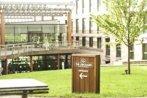 A wooden sign with "The Orchard Hotel & Restaurant" and an arrow pointing left for the entrance.