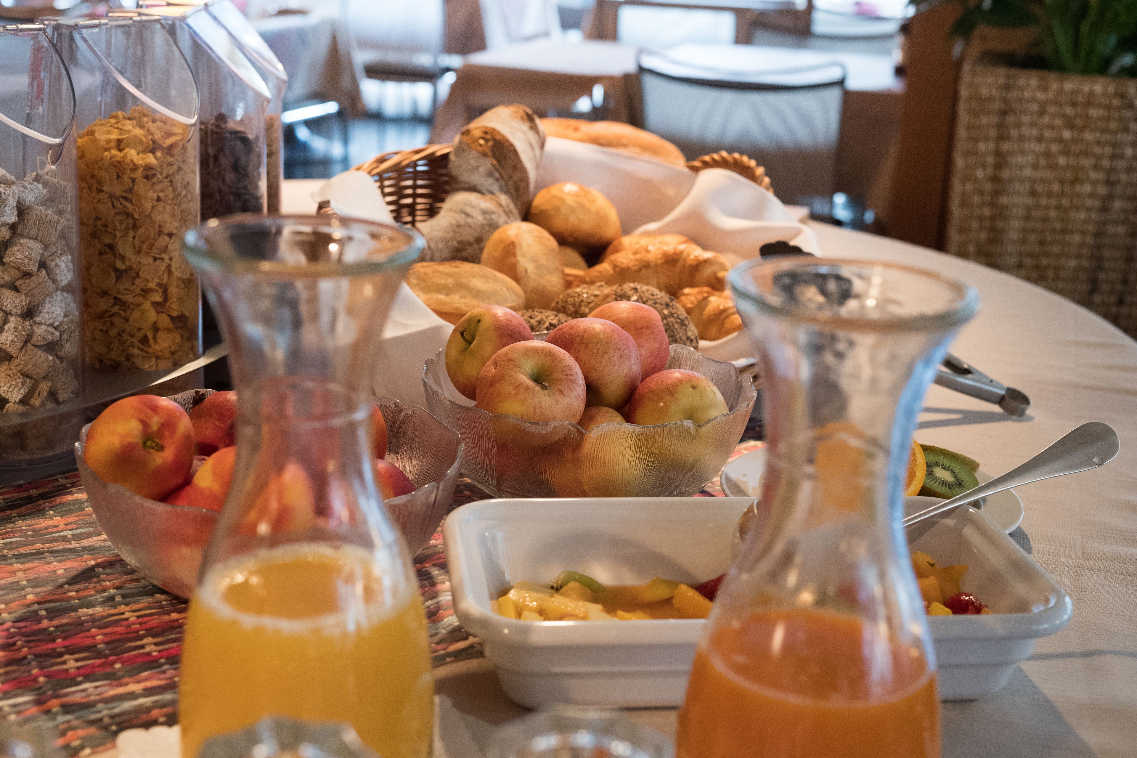 Een ontbijtbuffet met diverse soorten fruit, gebak en drankjes.