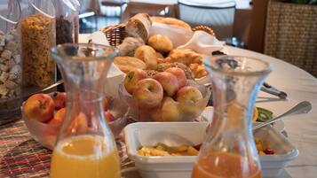 Een ontbijtbuffet met diverse soorten fruit, gebak en drankjes.