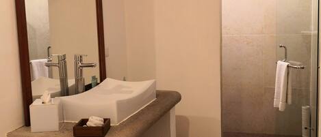 Une salle de bain avec un lavabo, un miroir et une douche.