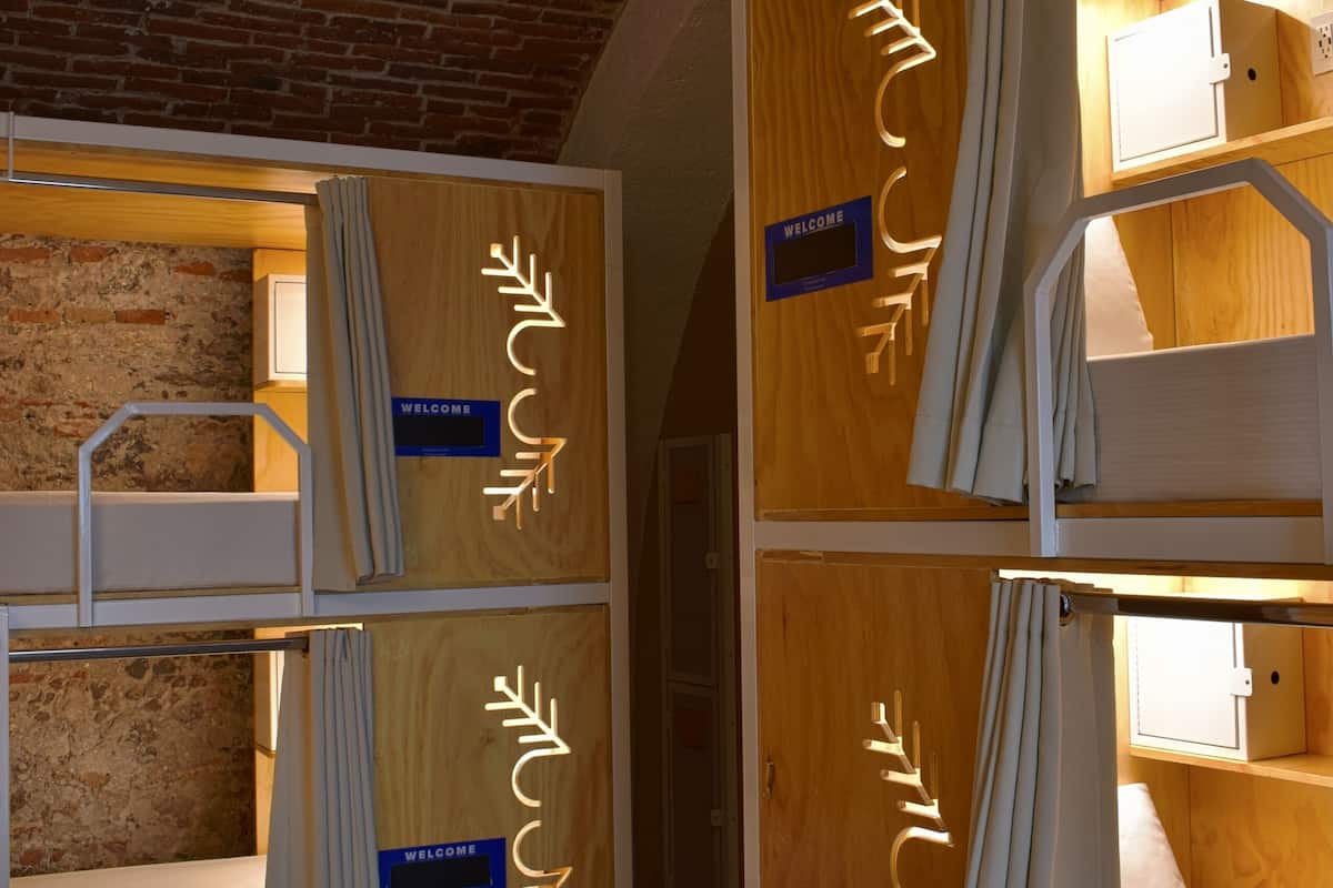 Una habitación de hotel con pared de ladrillo, muebles de madera y un cartel que dice 'Welcome'.