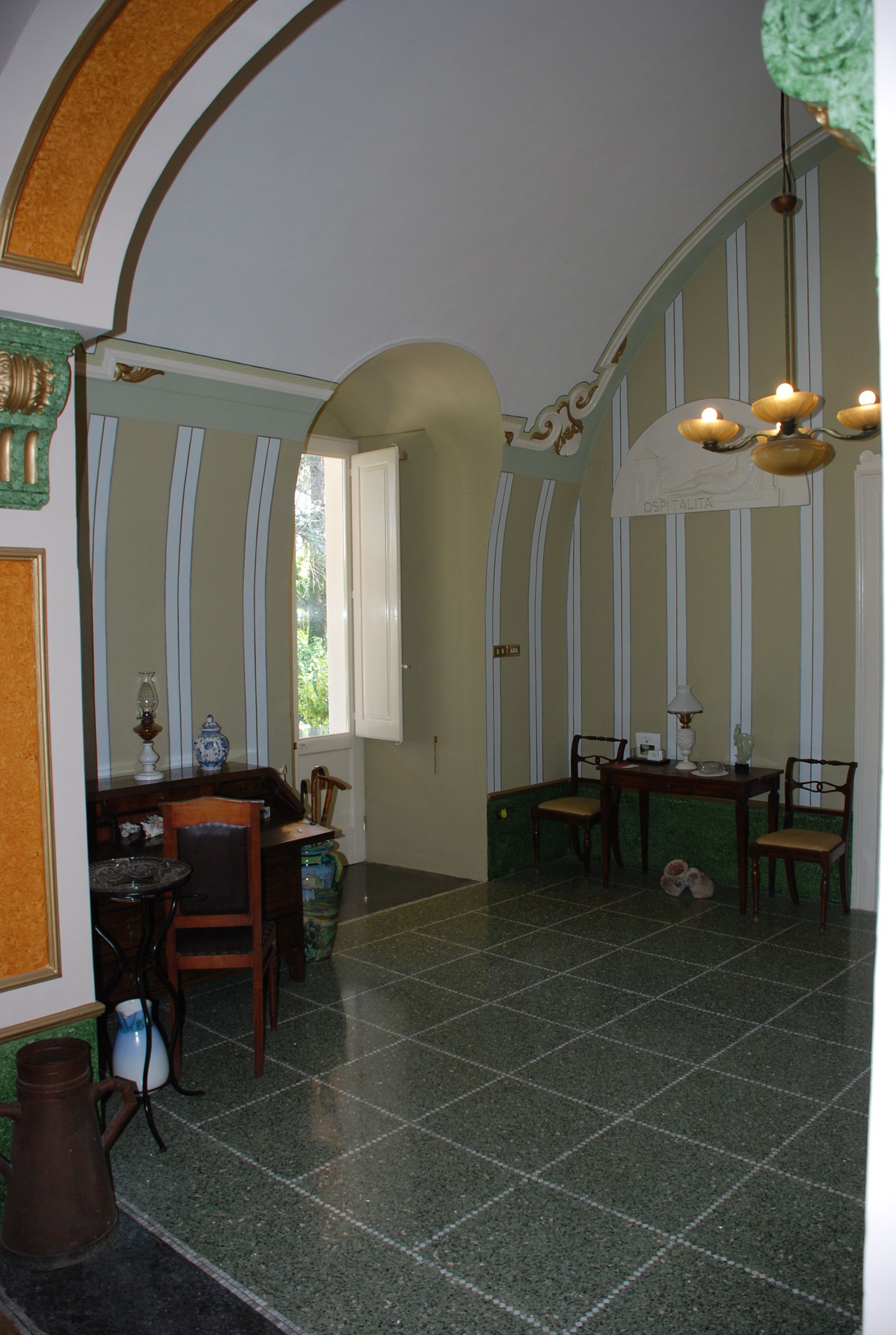 A dining area with a table and chairs, a chandelier, and a window with curtains.