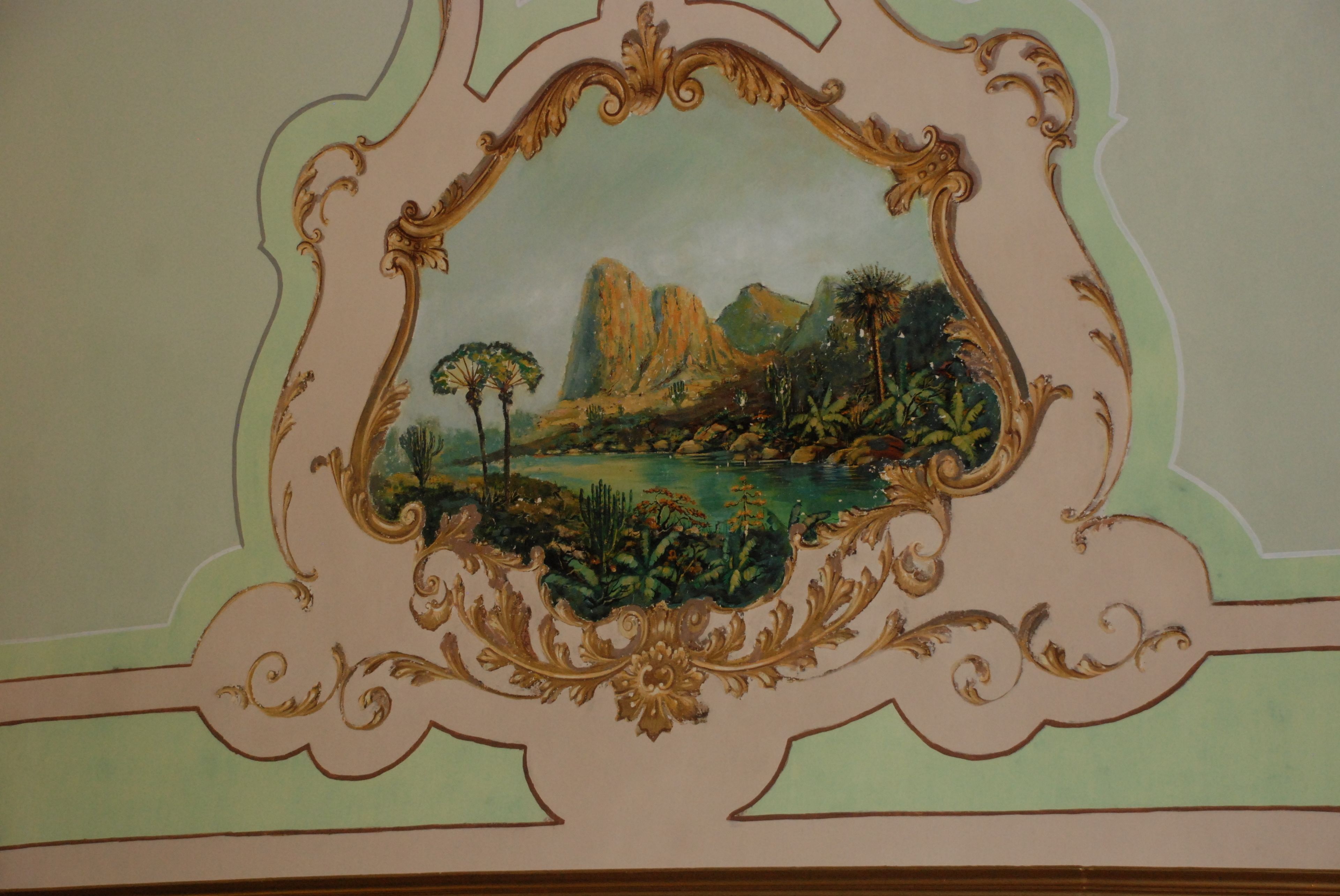 A ceiling with a decorative painting of a landscape.